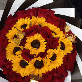 Bouquet of red roses and yellow sunflowers with butterfly picks