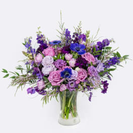 Purple and pink mixed bouquet in a clear glass vase
