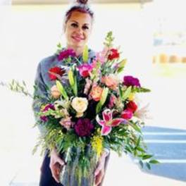 Woman holding a large mixed bouquet of colorful flowers