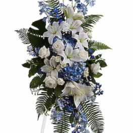 Tall white and blue floral standing spray on an easel