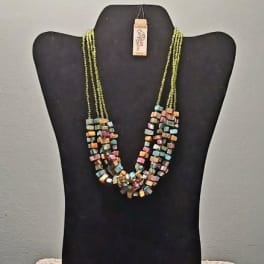 Multistrand beaded necklace on a black display bust