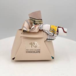 Beige chocolate gift box tied with a patterned ribbon