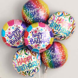 Cluster of colorful birthday balloons with printed messages