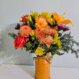 Mixed orange and yellow bouquet in a painted metal vase