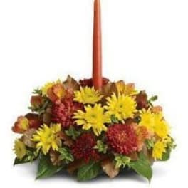 Autumn floral centerpiece with a tall orange taper candle