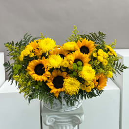 Yellow sunflowers and chrysanthemums in a white basket