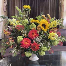 Large mixed bouquet with sunflowers, dahlias, and snapdragons in a white vase