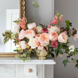 Blush and peach floral arrangement in a gold vase