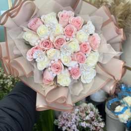 Bouquet of pink and white roses wrapped in blush paper