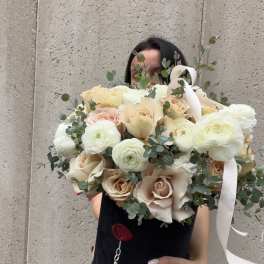 Large bouquet of cream roses and white ranunculus with eucalyptus and ribbon