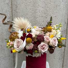 Mixed roses and small blooms in a burgundy hatbox with ribbon