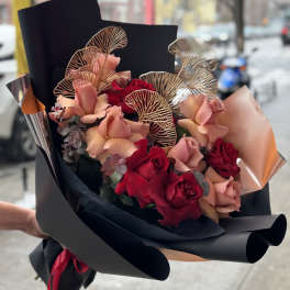 Bouquet of red and blush roses wrapped in black paper