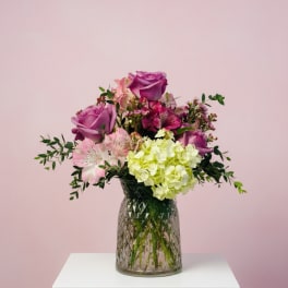 Pink and purple flower arrangement in a glass vase
