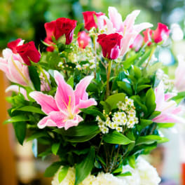 Bouquet of pink lilies and red roses with greenery