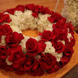 Red roses and white flowers arranged in a circular wreath