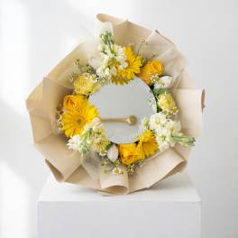 Yellow and white flower bouquet wrapped around a round mirror