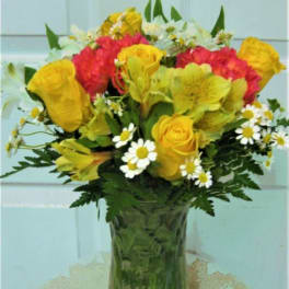 Bouquet of yellow and red flowers in a clear glass vase