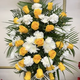 Yellow roses and white chrysanthemums in a tall standing arrangement