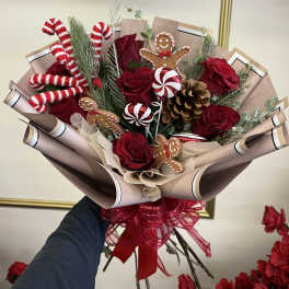 Bouquet of red roses with candy cane and gingerbread decorations