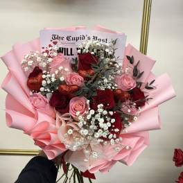 Bouquet of red and pink roses with baby’s breath in pink wrapping