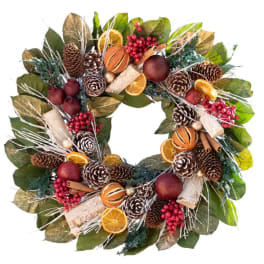 Holiday wreath with pinecones, dried orange slices, berries, and cinnamon sticks