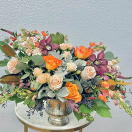 Mixed bouquet in a silver vase with orange and blush flowers