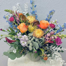 Colorful mixed flower arrangement in a white vase