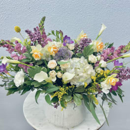 Mixed bouquet in a white vase with white, purple, and yellow flowers