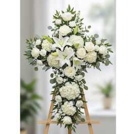 White floral cross arrangement on a wooden easel