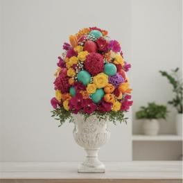Colorful floral arrangement in a white urn vase with decorative eggs