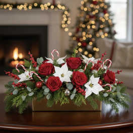 Christmas floral centerpiece with red roses and white poinsettias in a gold box