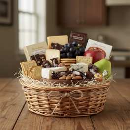 Gift basket with fruit, crackers, cheese, and chocolates in a wicker basket