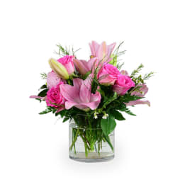 Pink lilies and roses in a clear glass vase