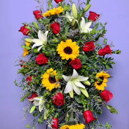 Standing spray with red roses, white lilies, and yellow sunflowers