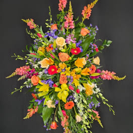 Large standing spray with mixed colorful flowers on a black background