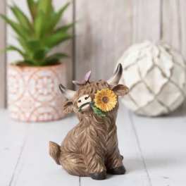 Small cow figurine with a sunflower on its face