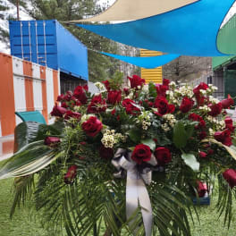 Large red rose arrangement with white filler flowers and palm fronds