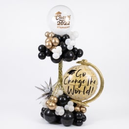 Graduation balloon display with black, white, and gold balloons