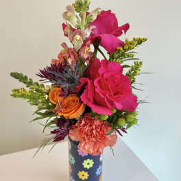 Bright mixed bouquet in a decorated cylindrical vase