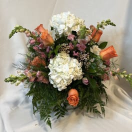 Bouquet of white hydrangeas and orange roses in a vase