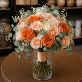 Peach and orange rose bouquet in a clear glass vase