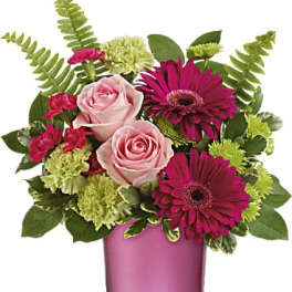 Pink roses and magenta gerbera daisies in a pink glass vase