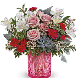 Pink and red rose bouquet in a pink glass vase