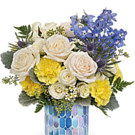 Bouquet of white and yellow flowers in a blue mosaic vase