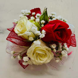 Small bouquet of red and cream roses with white filler flowers and red ribbon