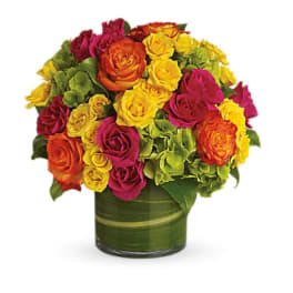 Mixed roses in yellow, pink, orange, and red arranged in a green vase