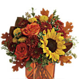 Autumn bouquet with sunflowers and roses in an orange vase