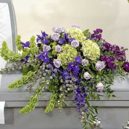 Purple and green floral casket spray with lavender roses and hydrangeas