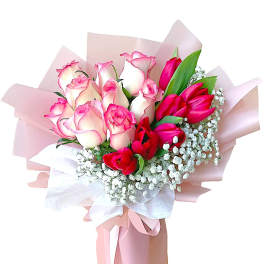 Bouquet of pink and red roses wrapped in pale pink paper