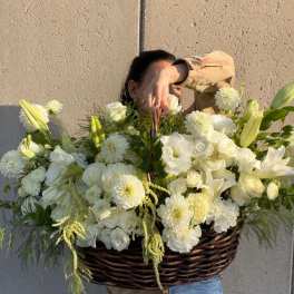 Large white flower basket with lilies, roses, and mums